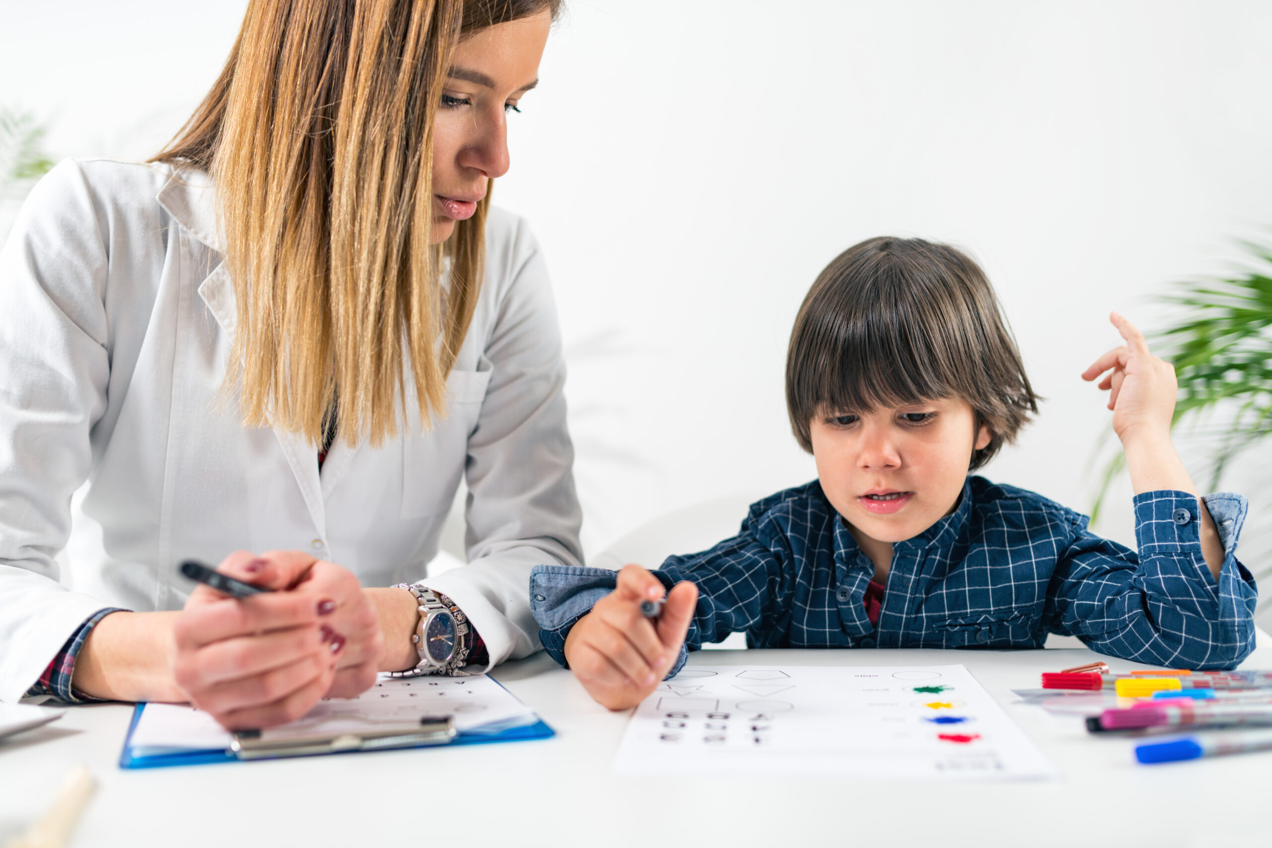 A therapist conducting a developmental assessment with a toddler using shape and colour cards