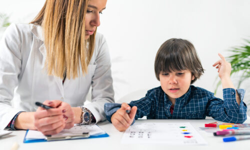A therapist guiding a toddler through a logic and shape-matching assessment
