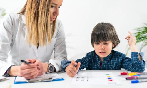 A therapist guiding a toddler through a logic and shape-matching assessment