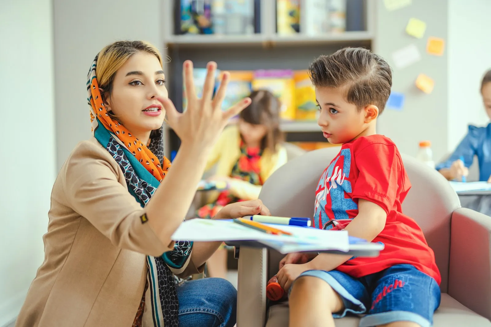 هل فرط الحركة له علاج: أخصائية تشرح لطفل باستخدام أصابعها أثناء نشاط تعليمي